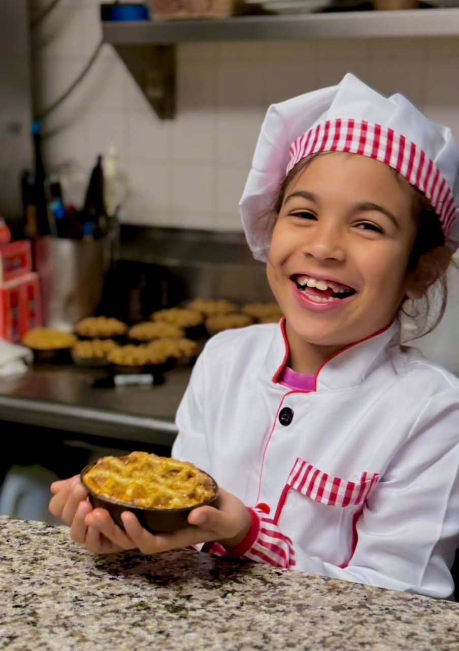 A young family baker presenting a freshly baked pastry